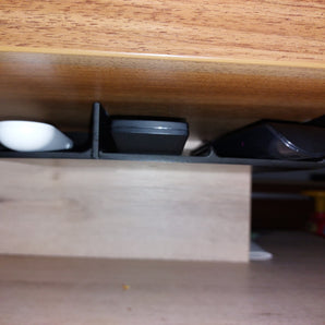 Soporte oculto para mando a distancia para un almacenamiento discreto debajo de la mesa