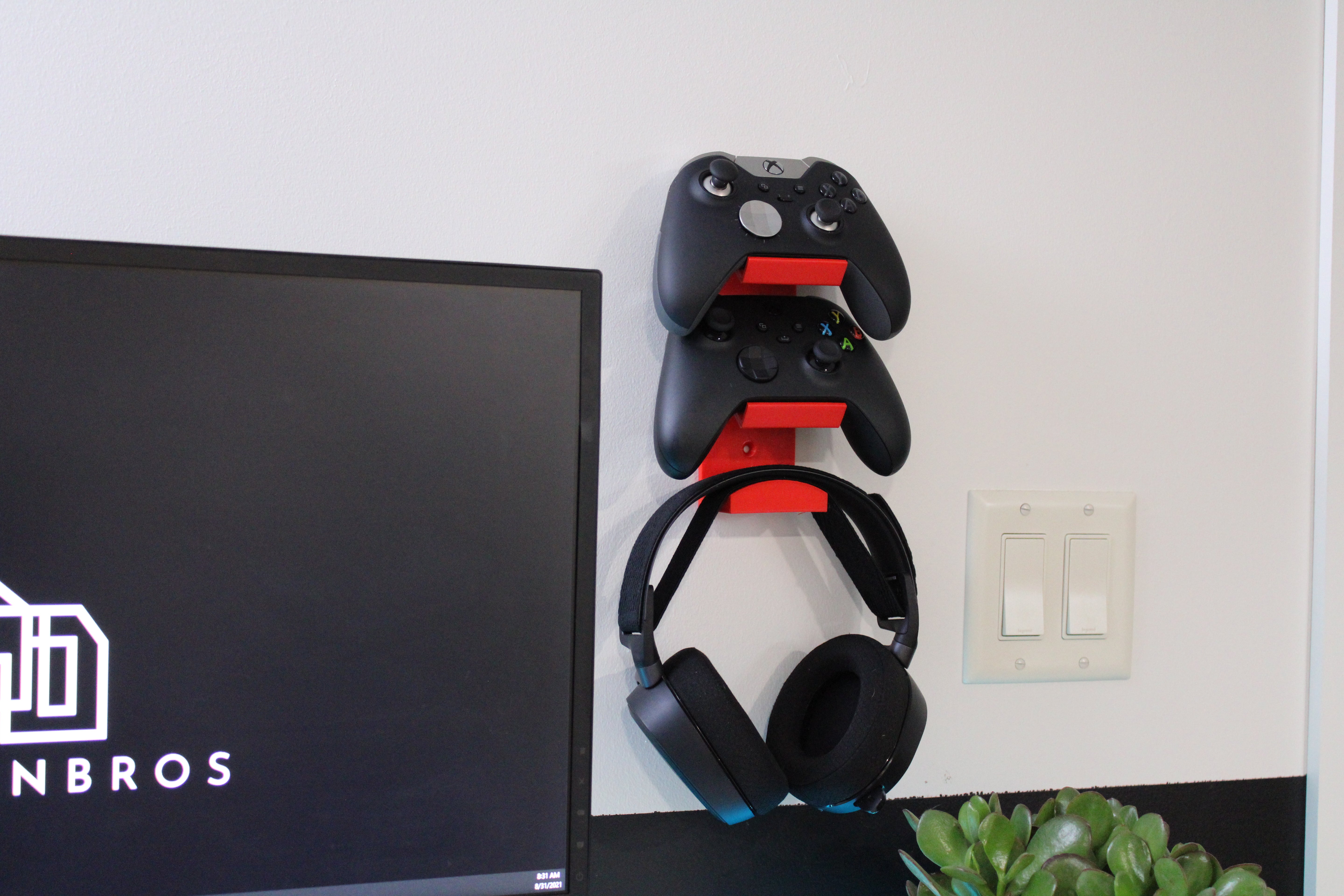 Soporte de pared para 2 mandos de juegos y auriculares